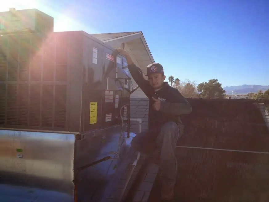 HVAC technician performing HVAC Inspection on a rooftop unit in Clifton Park